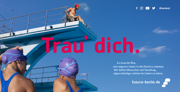Ein Mann im Rollstuhl steht auf einem Sprungturm über einem Schwimmbecken. Zwei Schwimmer:innen schauen zu ihm hoch. Der Himmel ist blau. Groß steht: „Trau' dich.“ Text daneben: „Wir helfen Menschen mit Handicap, eigenständiger mitten im Leben zu leben.“ futura-berlin.de
